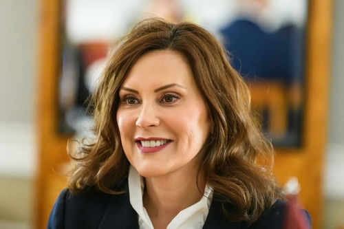 Person smiling indoors with blurred background
