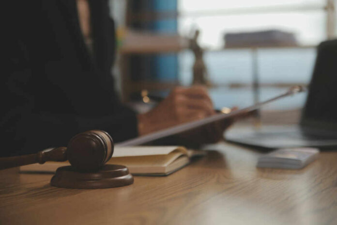 judge-gavel-with-justice-lawyers2483989077jpg Judge's gavel on desk with person writing in background