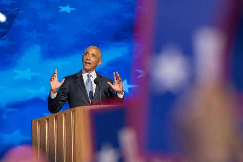 Man speaking at podium with blue starry background
