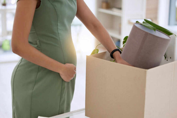 Pregnant woman packing items in cardboard box
