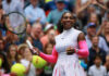 Tennis player smiling holding racket on court