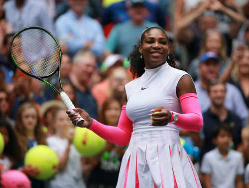 Tennis player smiling holding racket on court
