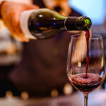 100% Tariff Shock — France Cornered A bartender pouring red wine into a glass