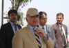 Ceasefire Hangs On Islamabad’s Whisper Network A group of men in formal attire at an outdoor event, with one man wearing a cap