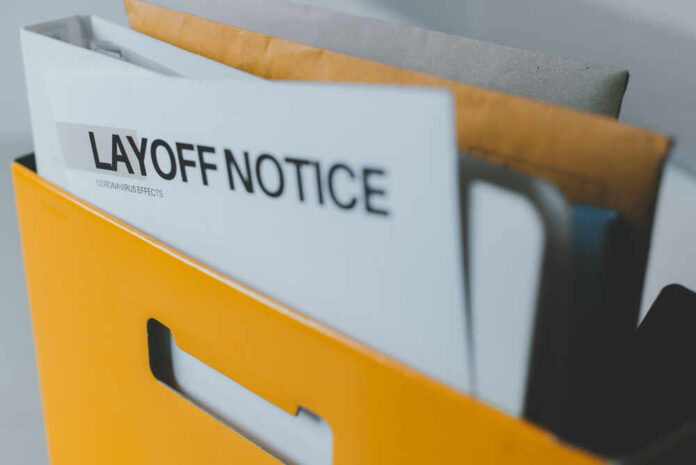Layoff,Notice,After,Spread,Of,Covid-19,(corona,Virus),,Crisis,Of A yellow folder containing a layoff notice and other documents