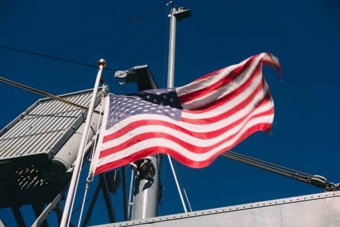 A naval destroyer displaying the American flag and various signal flags