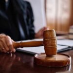 Virginia Muzzles ICE — DOJ Takes It To Court A judge's hand holding a gavel in a courtroom setting