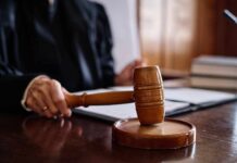 Virginia Muzzles ICE — DOJ Takes It To Court A judge's hand holding a gavel in a courtroom setting
