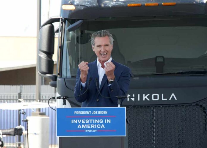 Oakland,,Ca,-,Aug,30,,2024:,Gavin,Newsom,Speaking,About A speaker passionately addressing an audience in front of an electric truck
