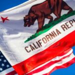 Transparency TAX Hits California California Republic flag waving alongside the American flag against a blue sky