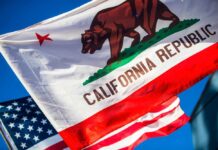 Transparency TAX Hits California California Republic flag waving alongside the American flag against a blue sky