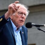 Boardroom Coup: Feds Take Voting Shares A man passionately speaking at a microphone during a public rally