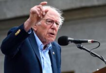 Boardroom Coup: Feds Take Voting Shares A man passionately speaking at a microphone during a public rally