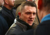 Man speaking intensely in a crowded outdoor setting
