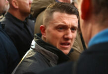 Man speaking intensely in a crowded outdoor setting