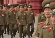 Military officers marching together in uniform.
