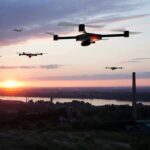 Drones flying over a river landscape at sunset