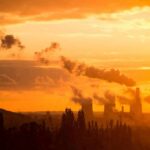 Power plant cooling towers emit smoke at sunset