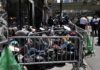 Unvetted Shelter Dump Near Brooklyn Schools? A crowded street with individuals sitting behind barriers and bags, highlighting urban homelessness