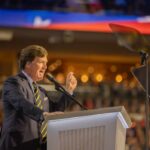 A speaker passionately addressing an audience from a podium