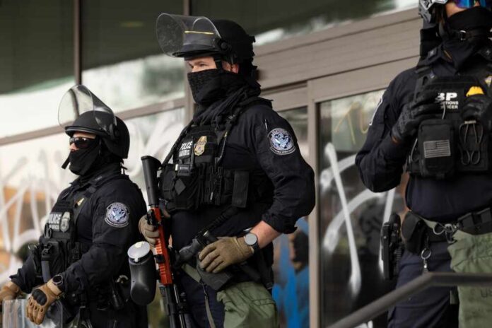 Los,Angeles,,California,,Usa,-,June,10,,2025:,U.s.,Customs Riot police in tactical gear stand guard outside a building