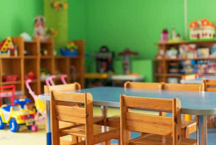 Chairs,,Table,And,Toys.,Interior,Of,Kindergarten. Brightly colored classroom with wooden tables and shelves filled with toys
