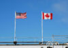 America’s Canada Grab Playbook American and Canadian flags flying on poles against a clear blue sky