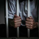 Terror Pipeline Exposed Inside America person gripping prison bars
