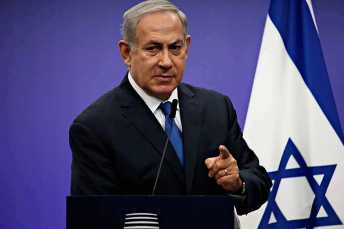 shutterstock_1042782061 man in suit speaking at podium with Israeli flag