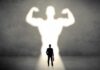 Exercise Without Sweat? Bioethics Alarm Bells Businessman with briefcase casts a large muscular shadow on wall