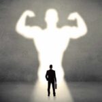 Exercise Without Sweat? Bioethics Alarm Bells Businessman with briefcase casts a large muscular shadow on wall