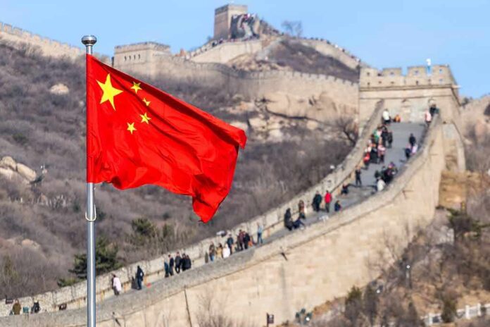 shutterstock_1145455832 Chinese flag waving with the Great Wall in the background