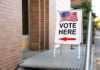 Undercover Sting Triggers State Threats Sidewalk sign with American flag directing to a polling place