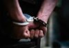 Masked Menace Hunted Coast-To-Coast hands in handcuffs behind back