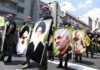 Nuclear Talk Inside Iran War Rooms? Protesters holding large portrait posters during a street march
