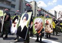 Protesters holding large portrait posters during a street march