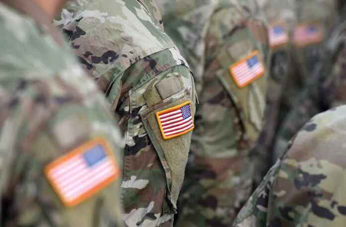 shutterstock_1507031834 U.S. flag patches on camouflage military uniforms