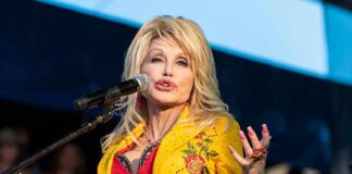 Singer performing on stage in a bright yellow floral jacket