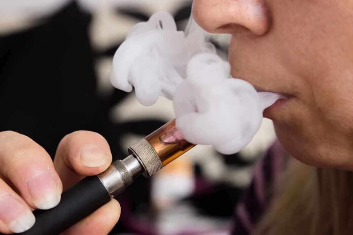 shutterstock_166583426 Close-up of a person vaping, exhaling smoke clouds