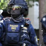 ICE Branded ‘Paramilitary’ — DHS Fires Back Riot police officer in tactical gear with helmet and visor