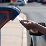 Court Greenlights Texas Mail-Vote ID Hand mailing an envelope into a blue mailbox