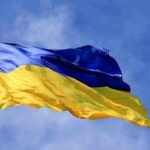 Bank Laundering Storm Hits Zelenskyy’s Circle Ukrainian flag waving on a flagpole against blue sky