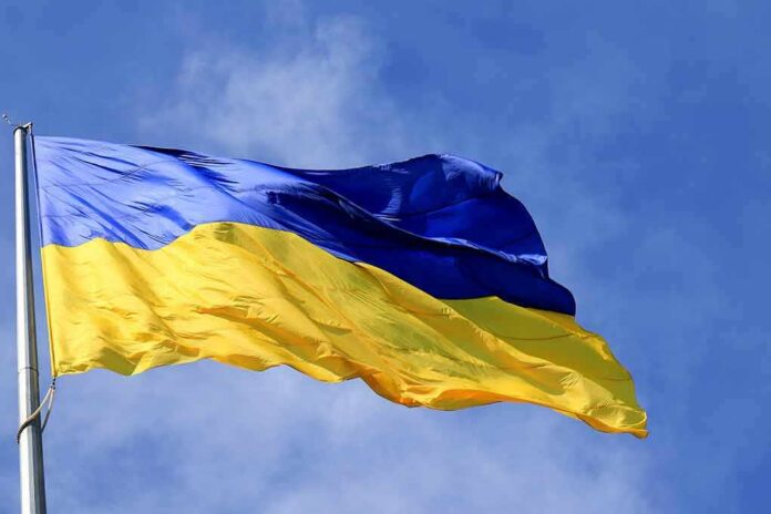shutterstock_2128824860 Ukrainian flag waving on a flagpole against blue sky