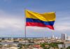 Pentagon Targets Kingpins In Colombia Colombian flag waving over a coastal city skyline