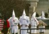 ku klux klan members in white robes and hoods at a public gathering