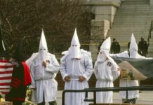 ku klux klan members in white robes and hoods at a public gathering