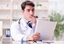Doctors Rebel: Forced Bias Lessons On Trial Doctor reviewing a file at a desk