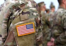 Iran Barrage Cripples Bahrain Nerve Center U.S. flag patch on a camouflage military uniform