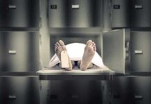 Body on morgue tray with toe tag and sheet