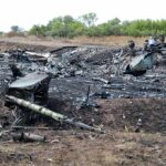Airplane crash debris scattered across a burned field